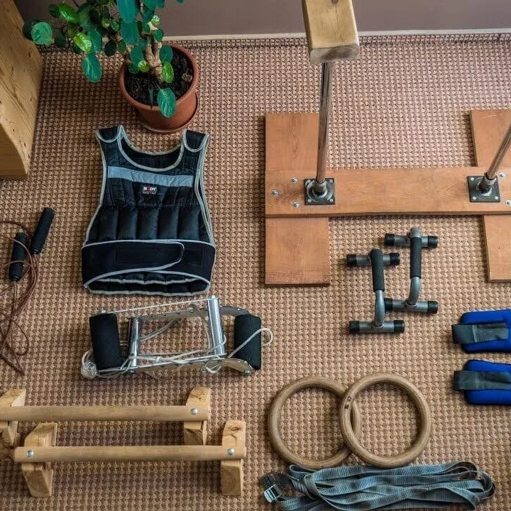 A room filled with various exercise equipment, including weights, mats, and machines, arranged on the floor.